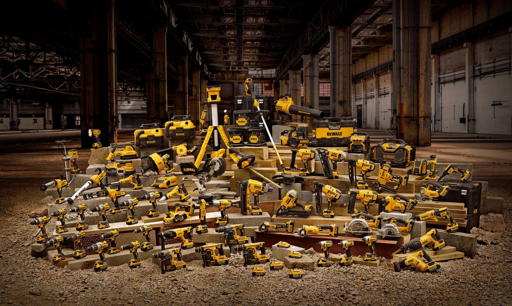Divers outils électriques DEWALT jaunes et coffrets exposés dans un entrepôt industriel.