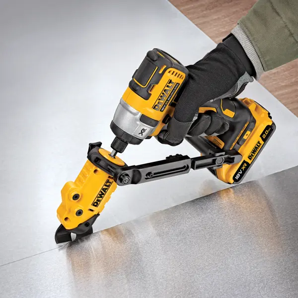 Outil DEWALT équipé coupe une tôle, utilisé par une main gantée.